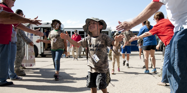 adults give military kid high fives